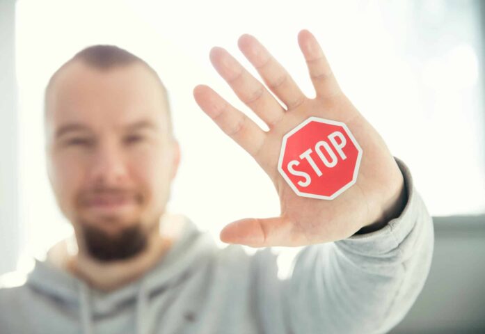 Eine gestreckte Hand stoppt eine Faust