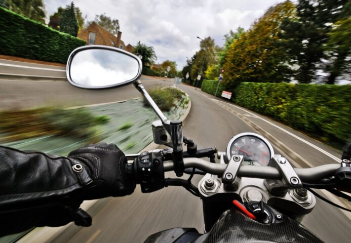 Das Bild zeigt einen schnellen Motorradfahrer in einer Kurve.